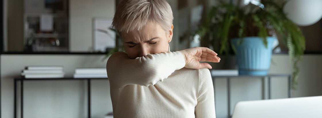 Das Bild zeigt eine Frau mit dem typischen Allergiesymptom von häufigen Niesen, was vor allem durch Schimmel hervorgerufen werden kann.